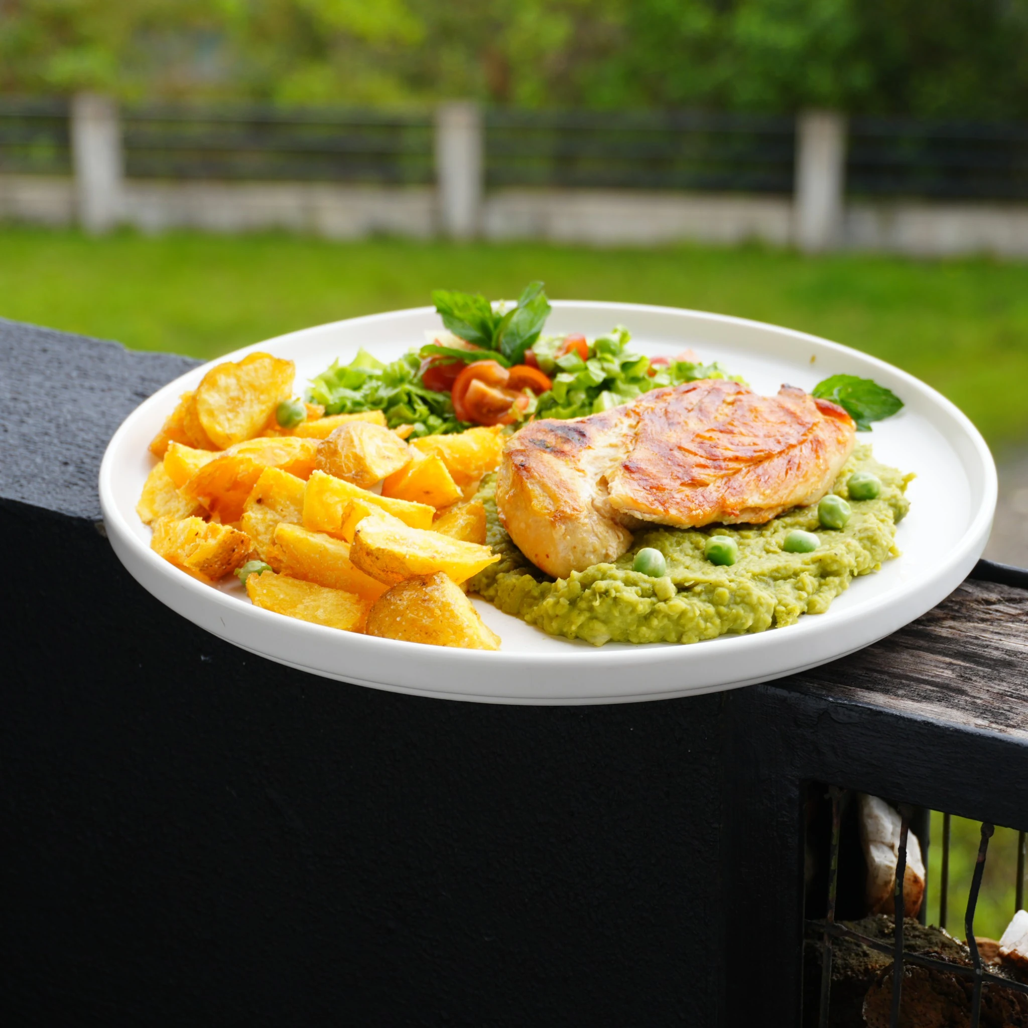 Pechuga de pollo servida con puré de arveja, papas y ensalada en Emerald Hotel Boutique